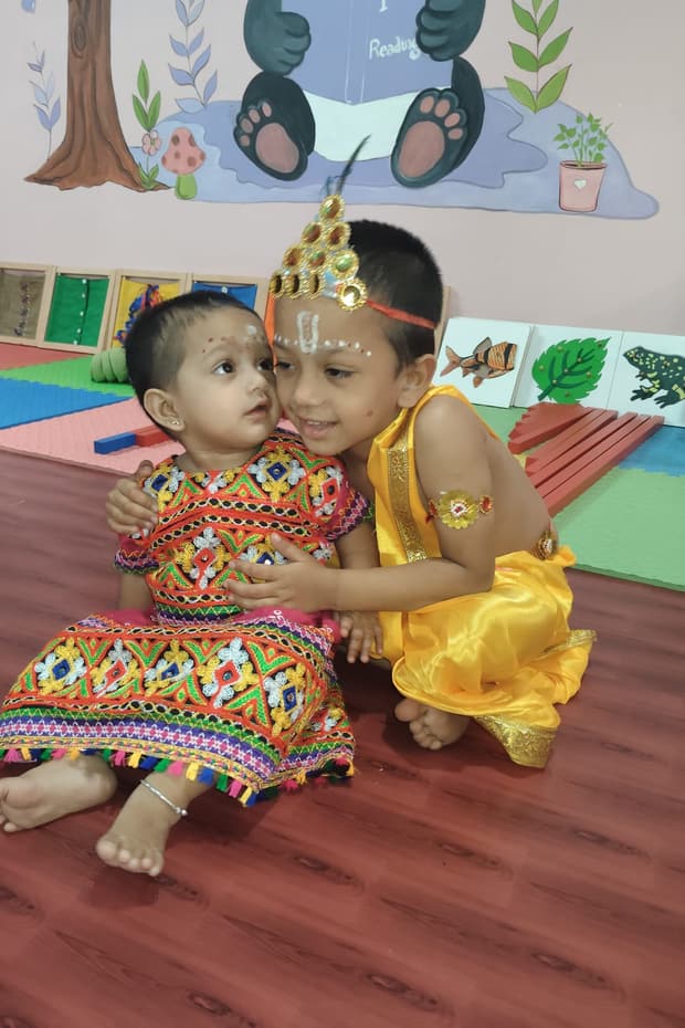 Children dressed in festive attire smiling together in the activity hall at Tiny Cradle