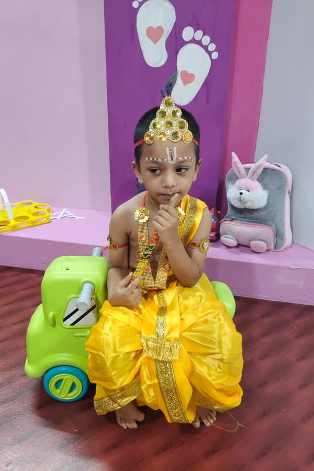 Child riding a colorful toy truck in the bright playroom at Tiny Cradle