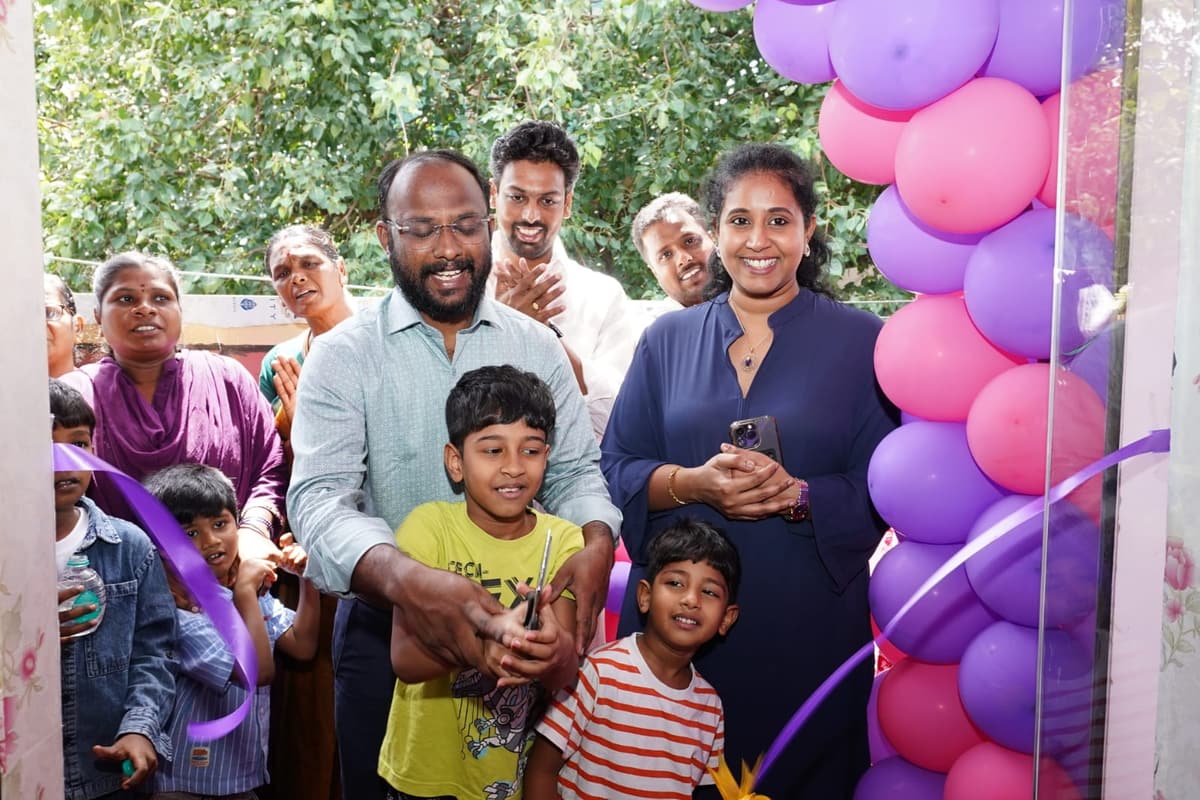 Dr. S. Premkumar and Dr. A. Agila guiding a child cutting the ceremonial ribbon at Tiny Cradle